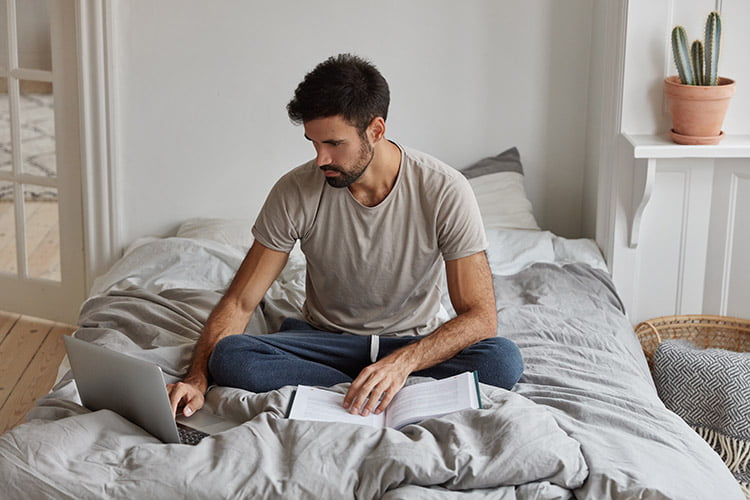guy studying in bed