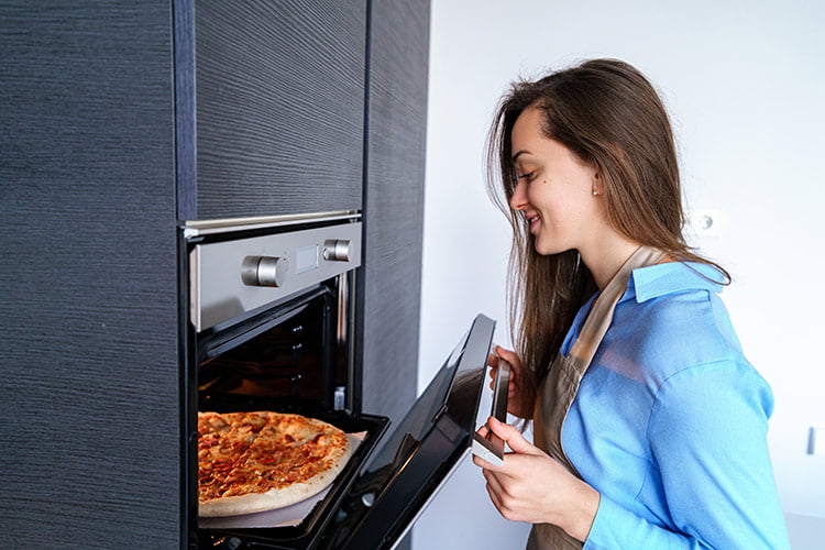 Woman looks into oven