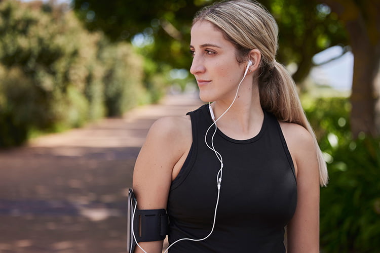 woman hearing podcast while jogging