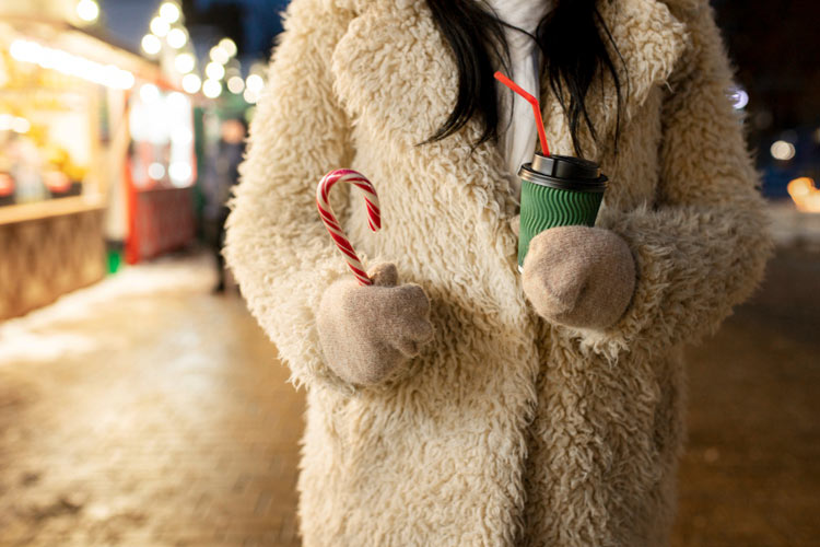 mit Kuschelmantel und Zuckerstange am Weihnachtsmarkt