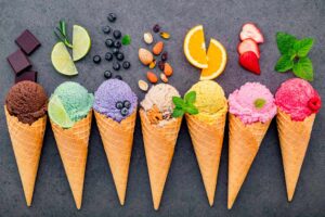Verschiedene Ice Cream Sorten in Cones mit den verschiedenen Rohstoffen on top